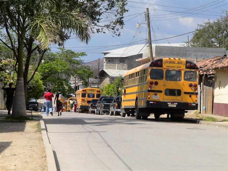 Former American school buses on a street in Comayagua